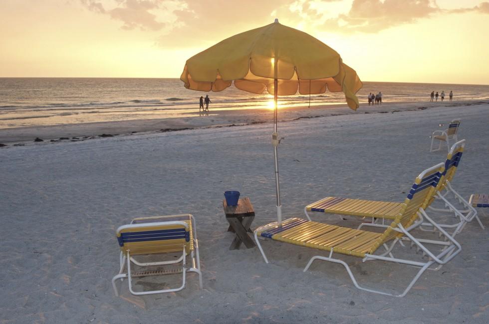 Beach chairs and umbrellas at sunset, Clearwater, Florida.;