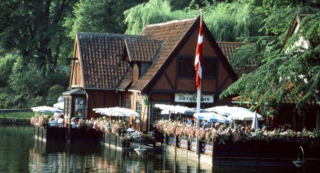 The thatched-roof restaurant Faergekroen overlooks a lake.