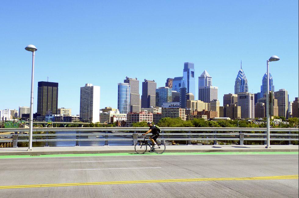Philadelphia, PA, USA &#x2013; August 28, 2014: Bicyclist on the South Street Bridge with the Philadelphia Skyline behind him.