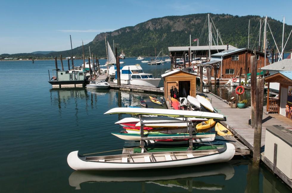 Canoes, motorboats, fishing boat and sailboats in the harbour at Cowichan Bay, British Columbia.