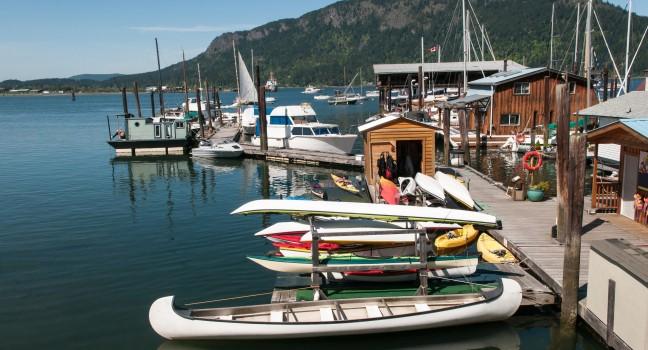 Canoes, motorboats, fishing boat and sailboats in the harbour at Cowichan Bay, British Columbia.