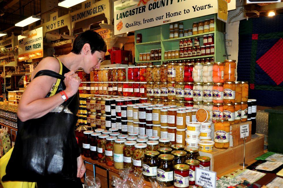 Woman shopping for delicious homemade preserves sold by an Amish family at the Reading Terminal Market in Philadelphia, Pennsylvania.