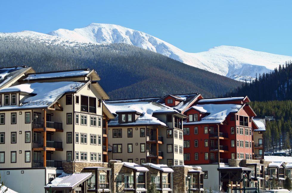 Ski lodges at Winter Park, Colorado with a view of the Rocky Mountains in the background.