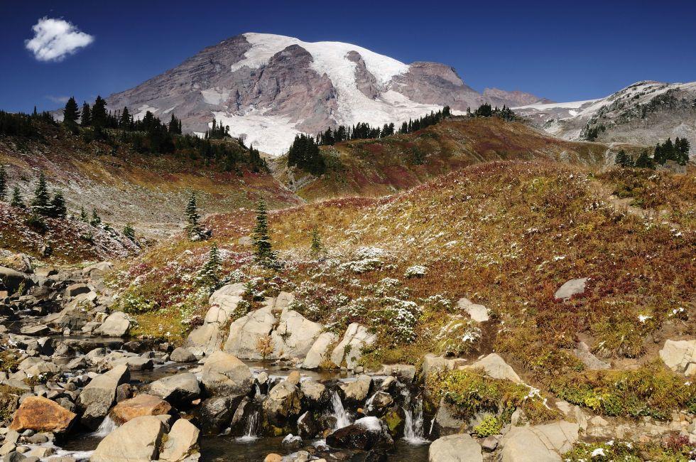 Majestic Mount Rainier blushing with valleys covered with fall colors.