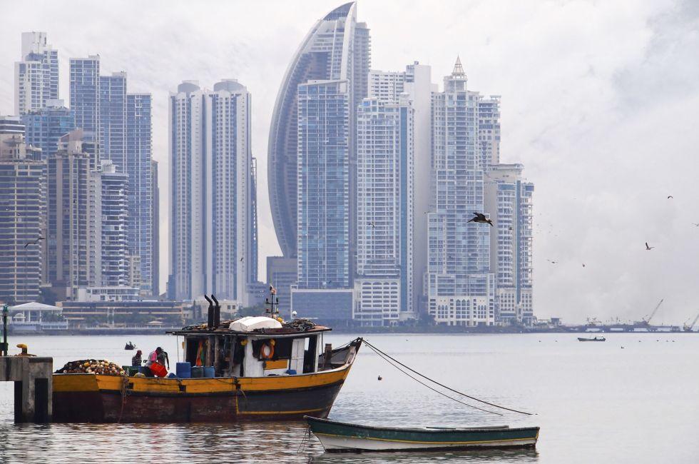 Old fishing boat in foreground with skyscrapers in background, Panama City , Panama, Central America
