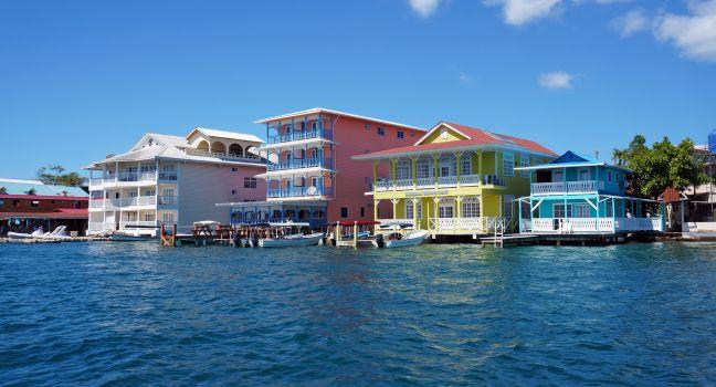 Colorful Caribbean buildings over the water with boats at dock, Colon island, Bocas del Toro, Panama