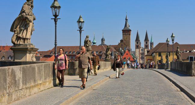 WURZBURG, GERMANY - APRIL 20th 2011: People walking over the Alte Mainbrucke in Wurzburg with many nice statues of saints is known as the oldest bridge (built 1473-1543) on a sunny spring day