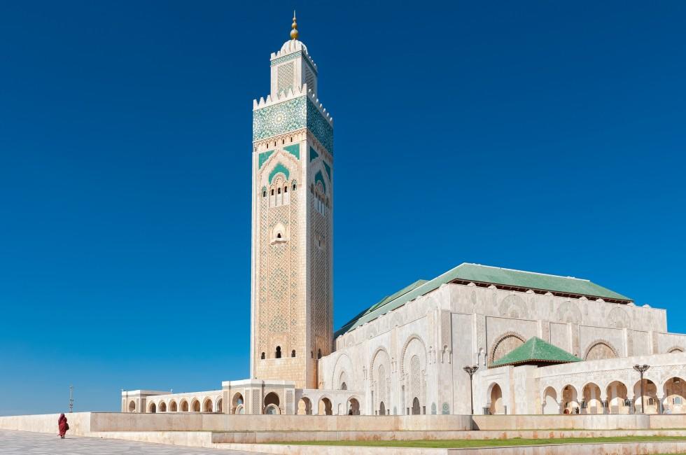 Side view of a modern mosque Hassan II in Casablanca, Morocco. The highest in the world minaret is painted in a traditional Islamic green color. Mosque is located half on land and half on water.; 