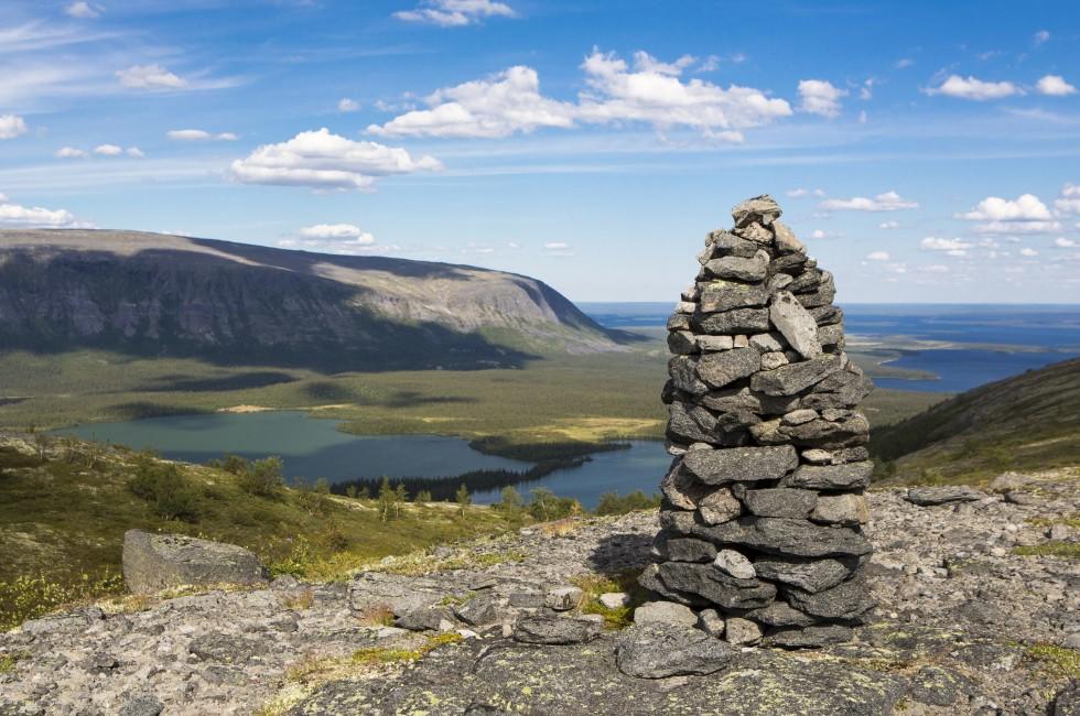 Russia. Murmansk region. Massif  Lovozero. Siedi from stones against mountains, the lake and the sky with clouds.