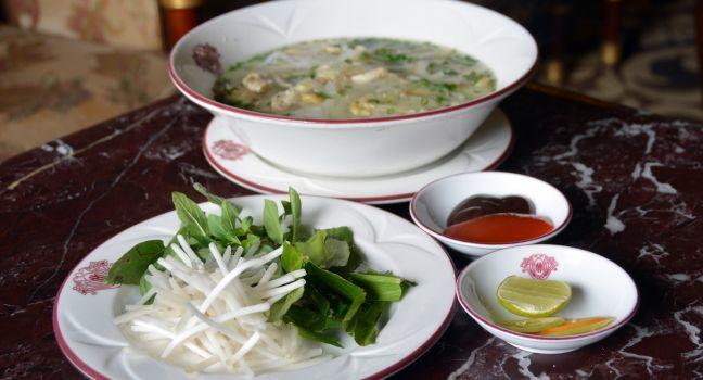 Ho Chi Minh City, Vietnam - April 05, 2015: Chicken Noodle Soup (Pho Ga) is the national dish in Vietnam. It is served here at the Majestic Hotel with Chilli sauce, Limes, Chillies, Bean Sprouts and Lemon Grass which may optionally be added to the soup.