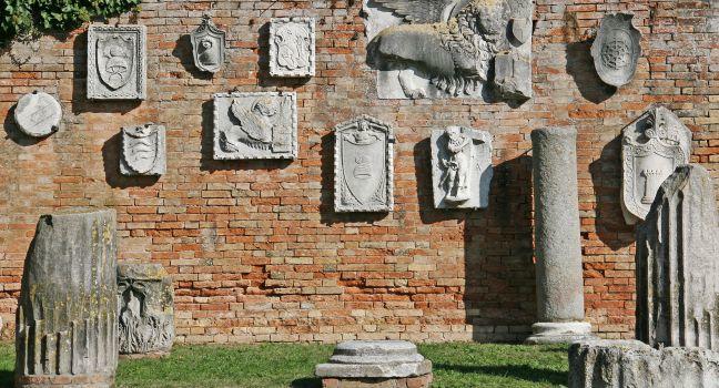 Wall with old reliefs in island of Torcello, Italy.