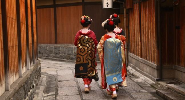 Three geishas walking on a street of Gion (Kyoto, Japan).